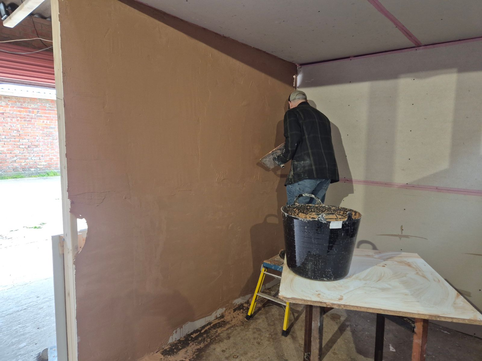 Learner applying plaster to a wall during live training