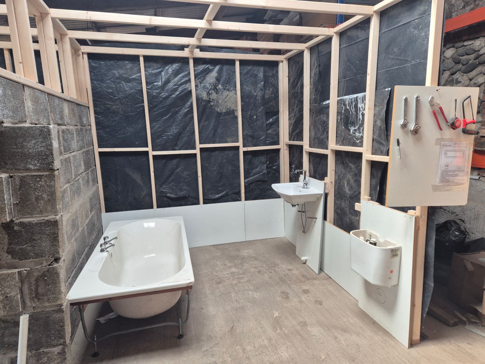 Plumbing training workshop mock room under construction for hands-on bathroom fitting practice