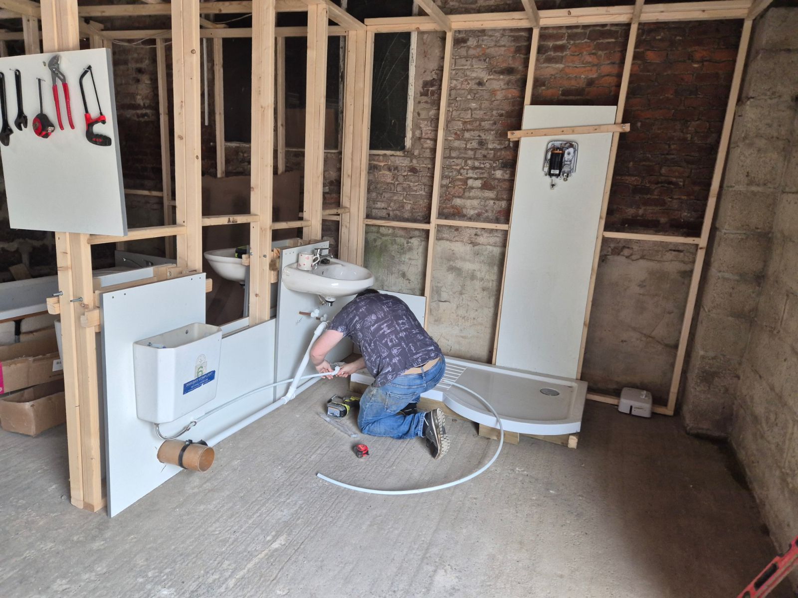 Learner fitting plasterboard panels during practical bathroom training